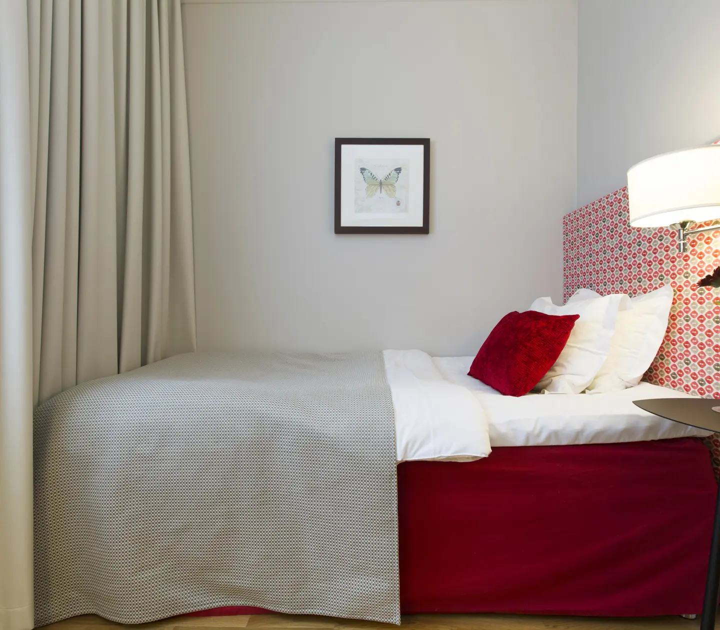 Hotel room with single bed, lamps and painting