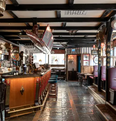 Pub environment with seating, bar and bottles