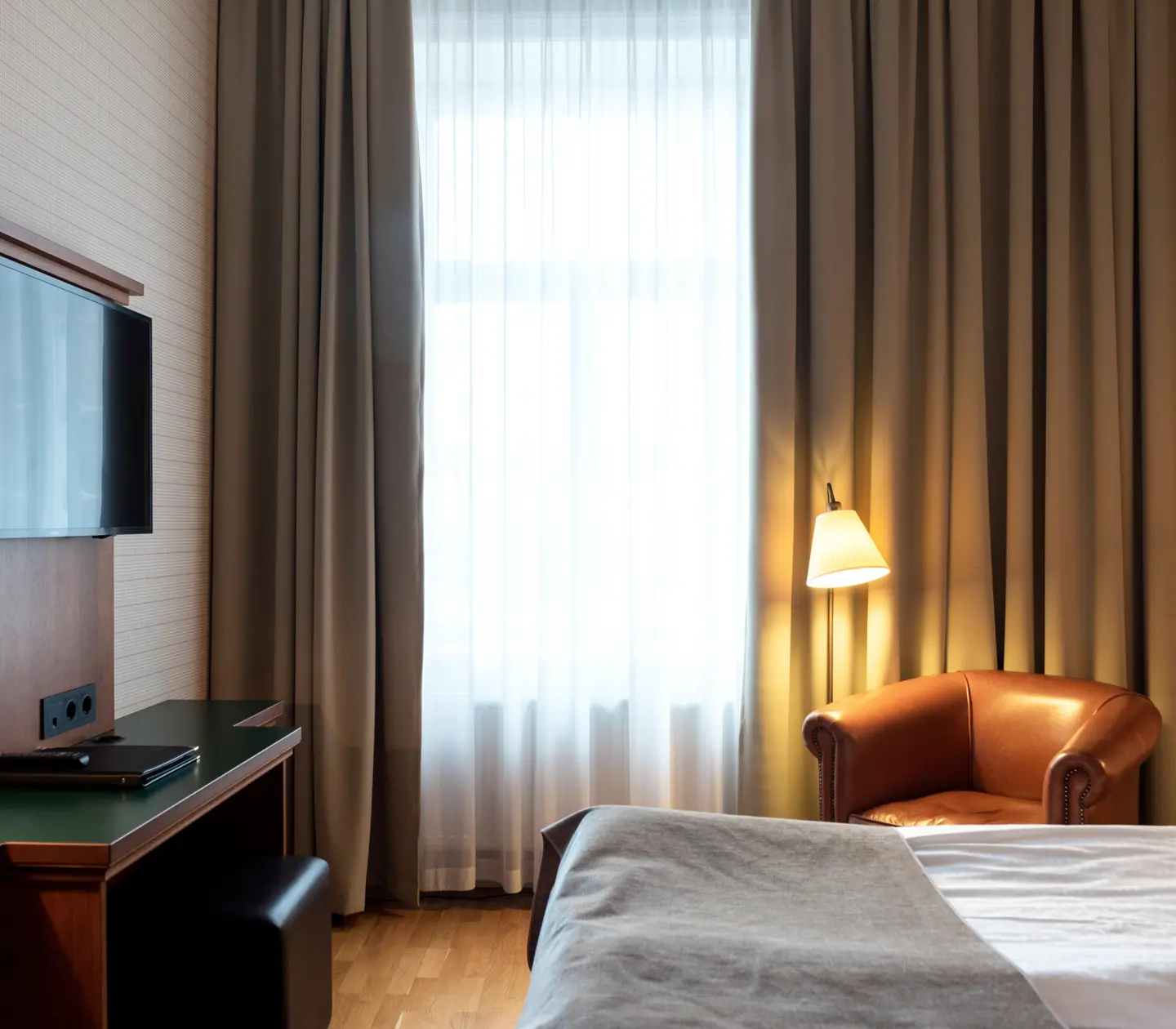 Hotel room with bed, leather armchair and TV