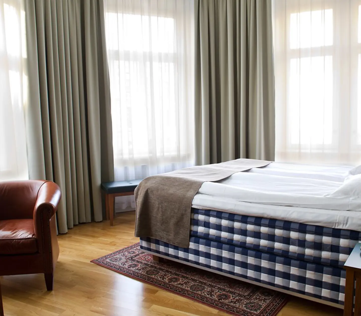 Hotel room with Hästens bed, leather armchair and window