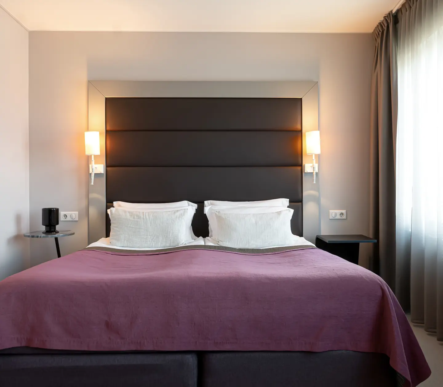 Hotel room with double bed, armchair and large windows
