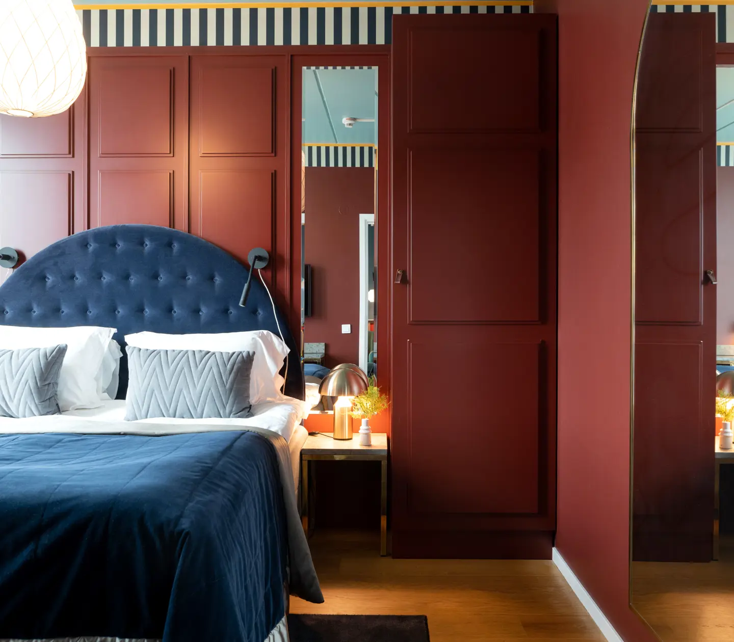 Cozy suite with dark red walls, bed and mirror