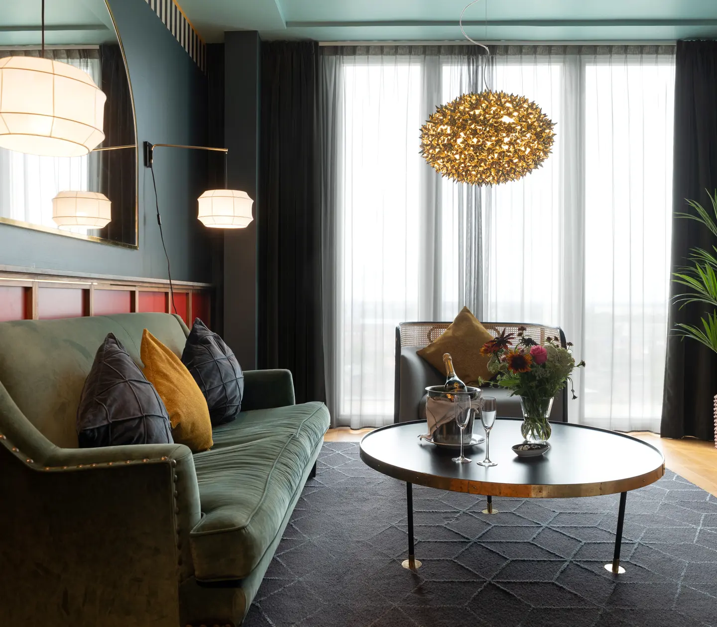 Cozy suite with blue and red walls, sofa group and large window