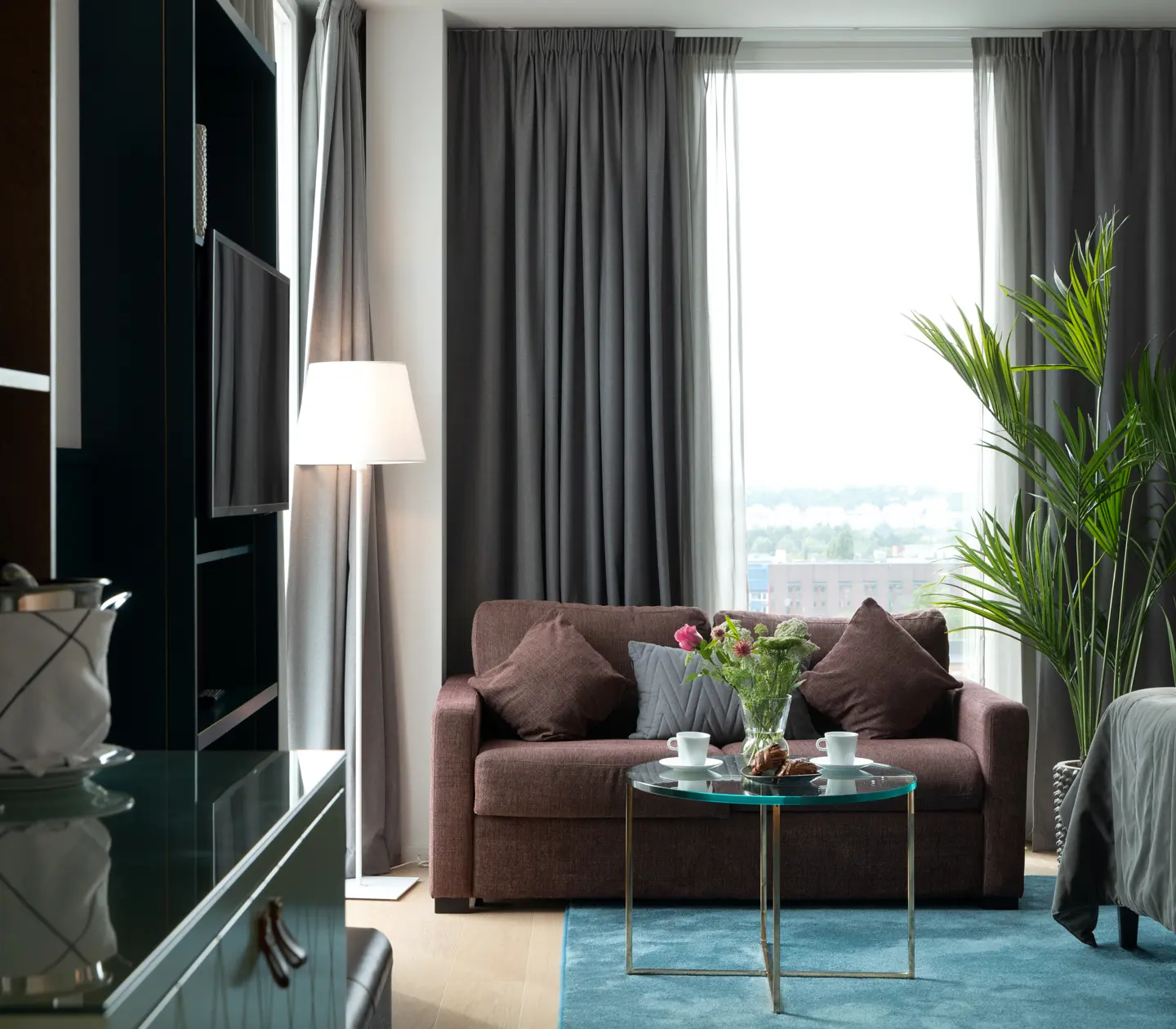 Cozy suite with bookshelf, sofa and large window