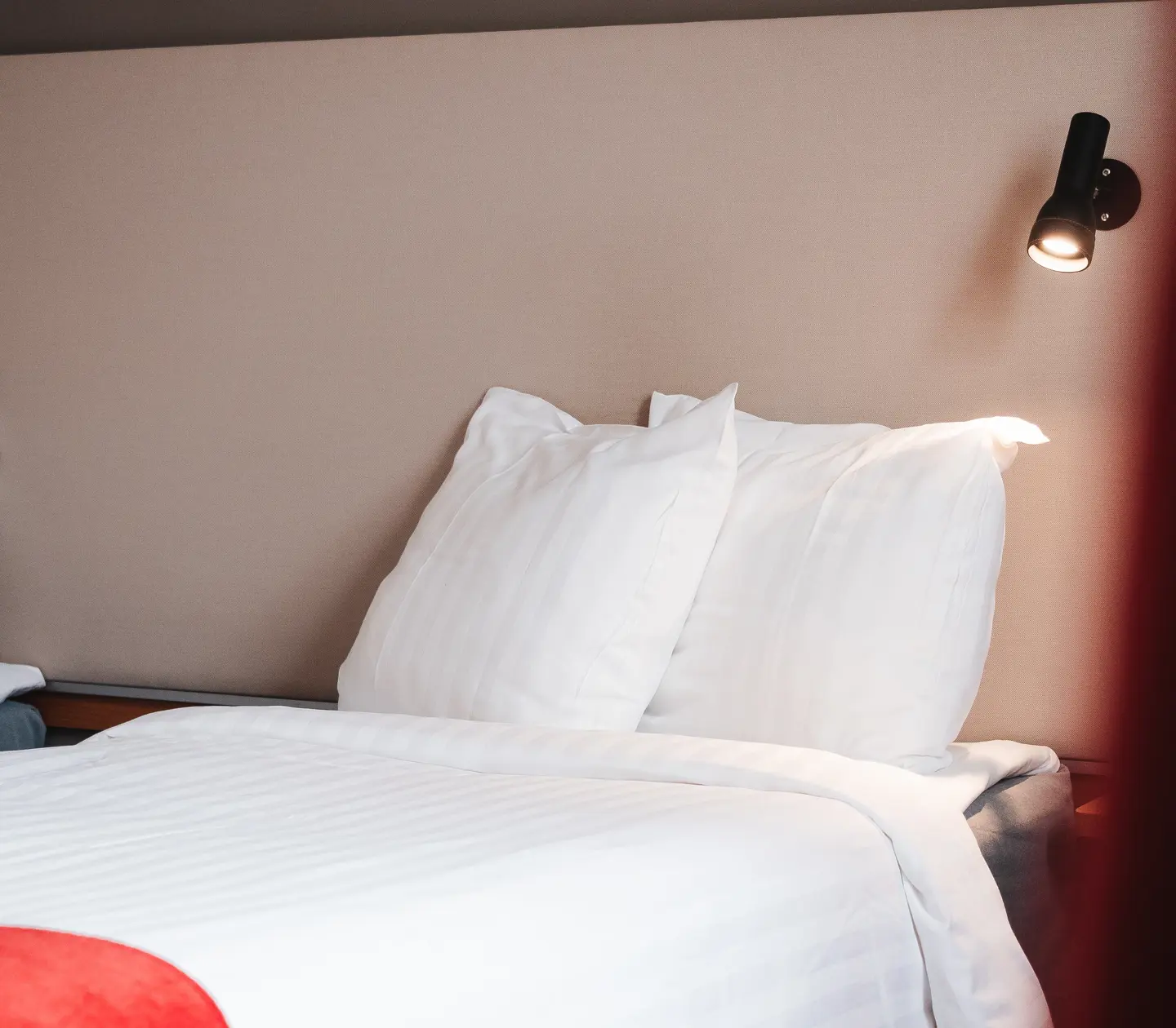 Close-up of bed, bedside lamp and pillows
