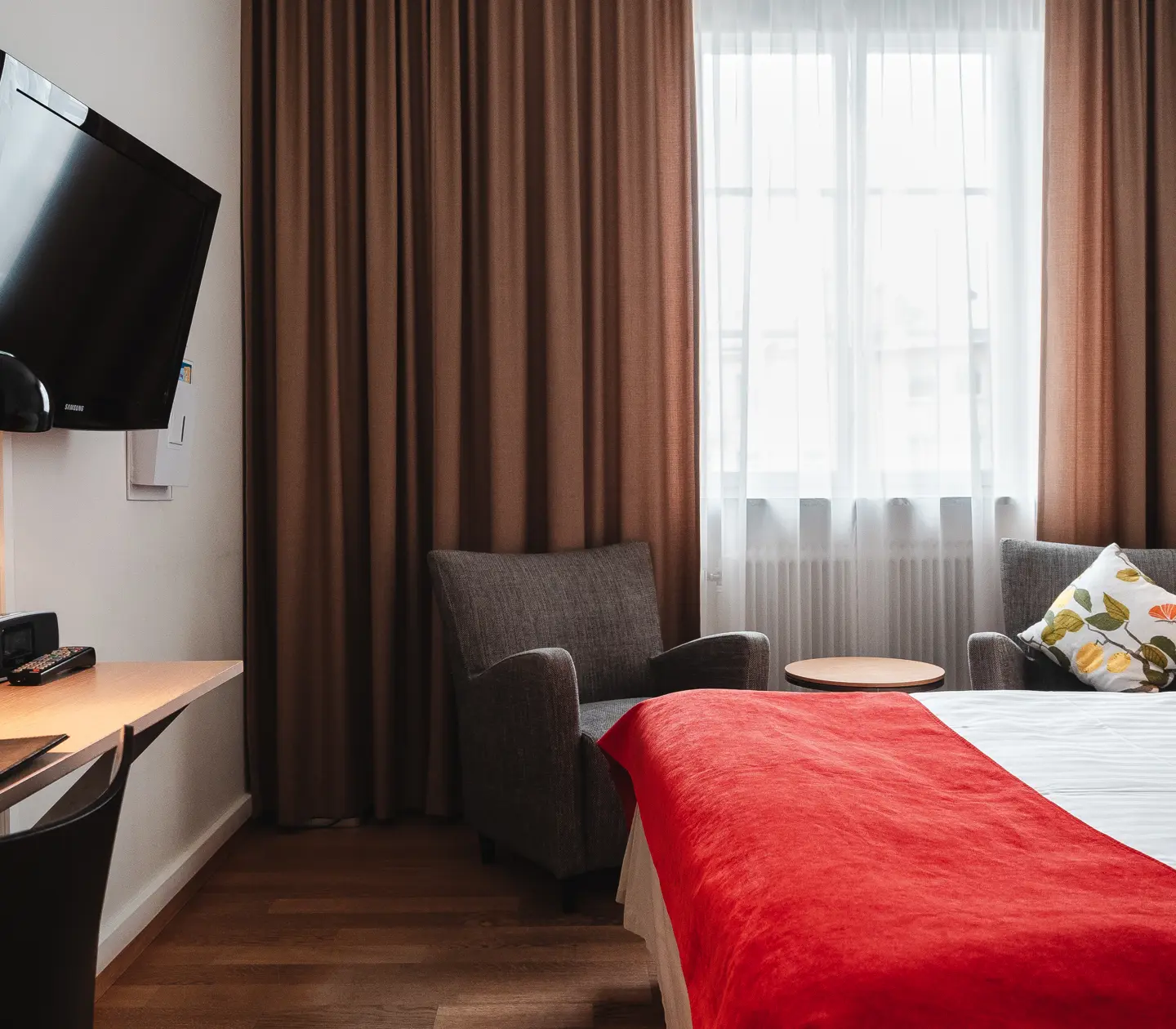 Cozy hotel room with bed, armchairs and TV