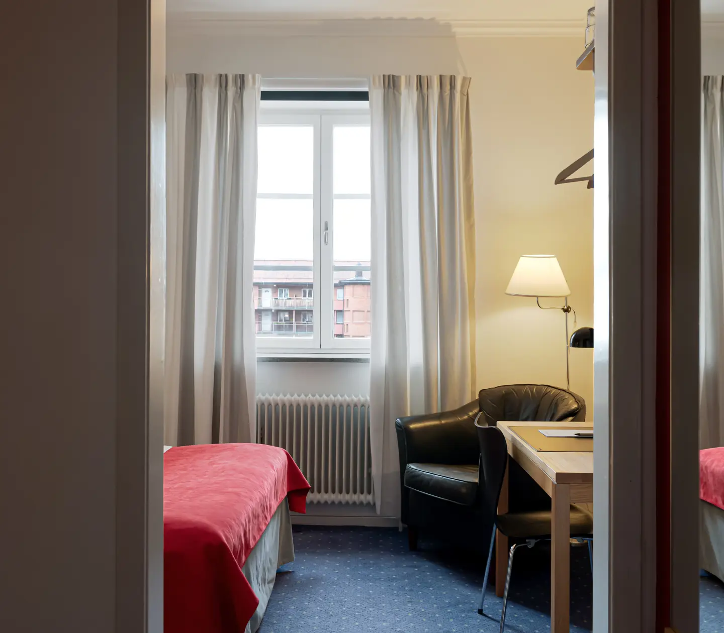 Hotel room with desk, armchair and window